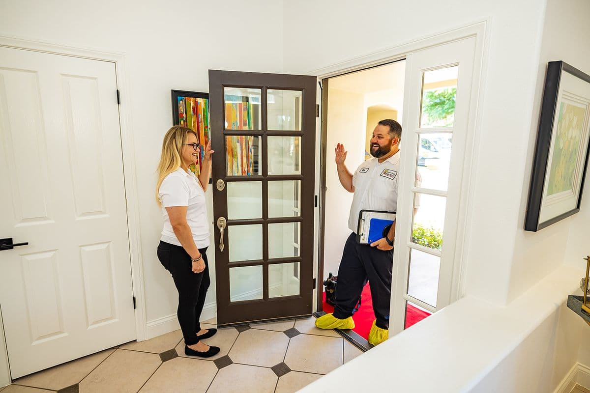 A Home Team Electric electrician greeting a homeowner at the door at the end of a service call